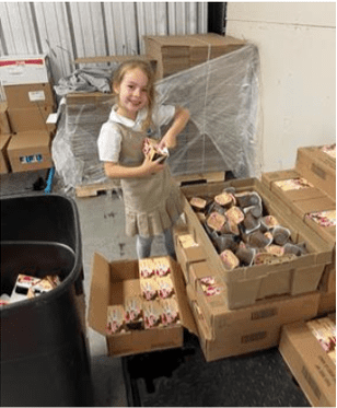Skylar Greene helps pack lunch boxes for Help 4 Kids Florence